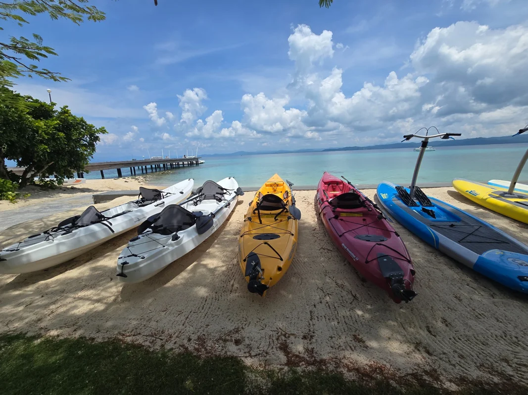 Kayaks and paddleboards lined up on a quiet Philippine beach