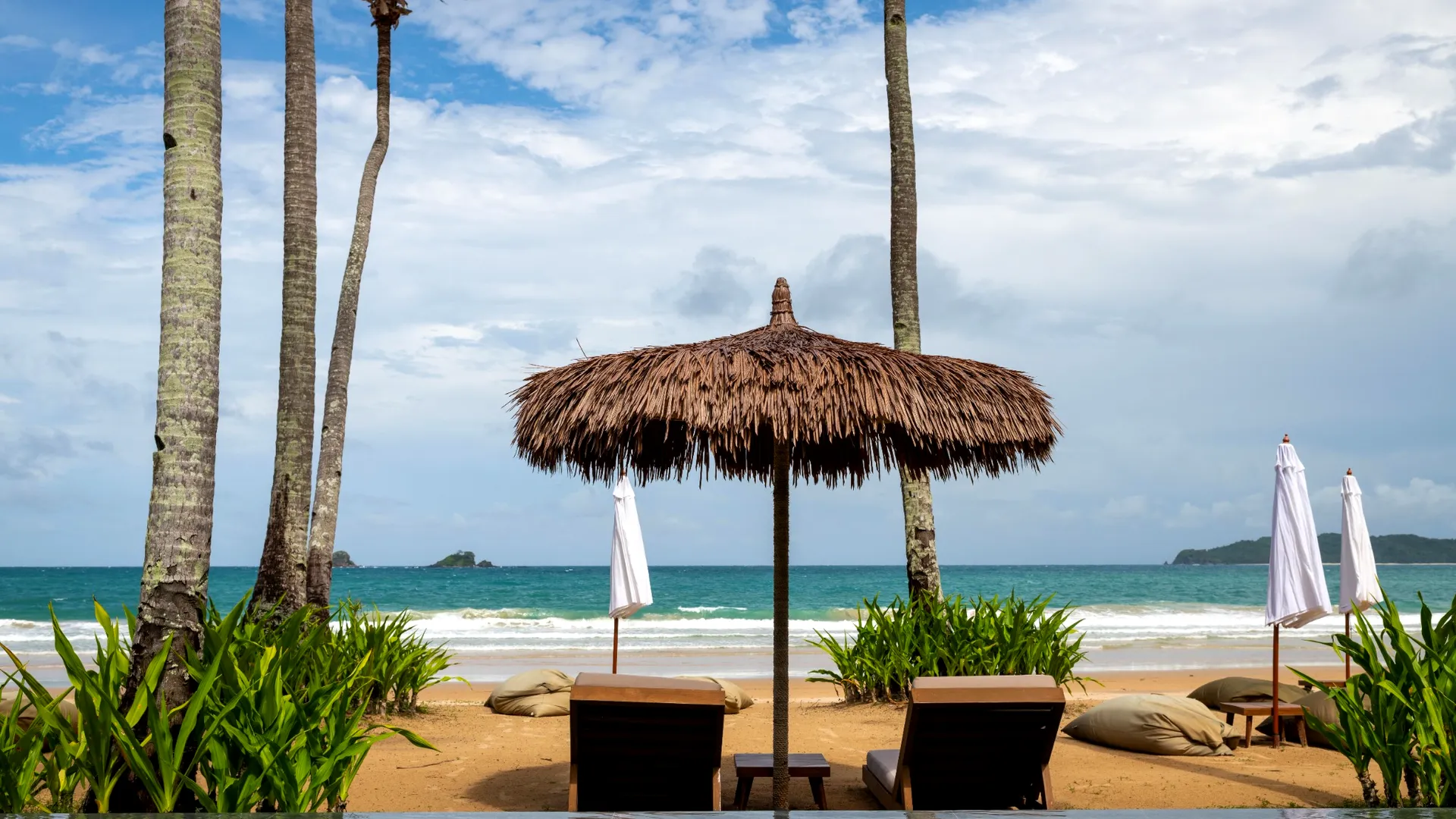 Two sun loungers set on the white sand at the water's edge on Boracay's White Beach