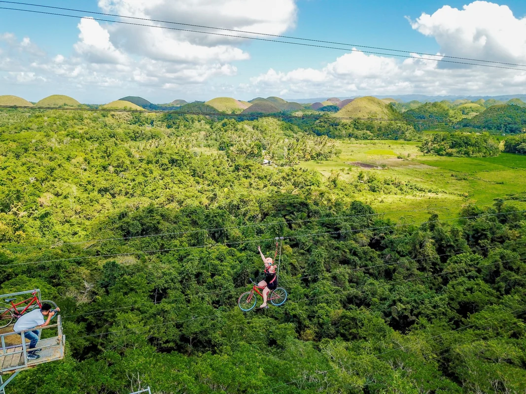 A rider on a bike adventure course overlooking the Chocolate Hills, Bohol